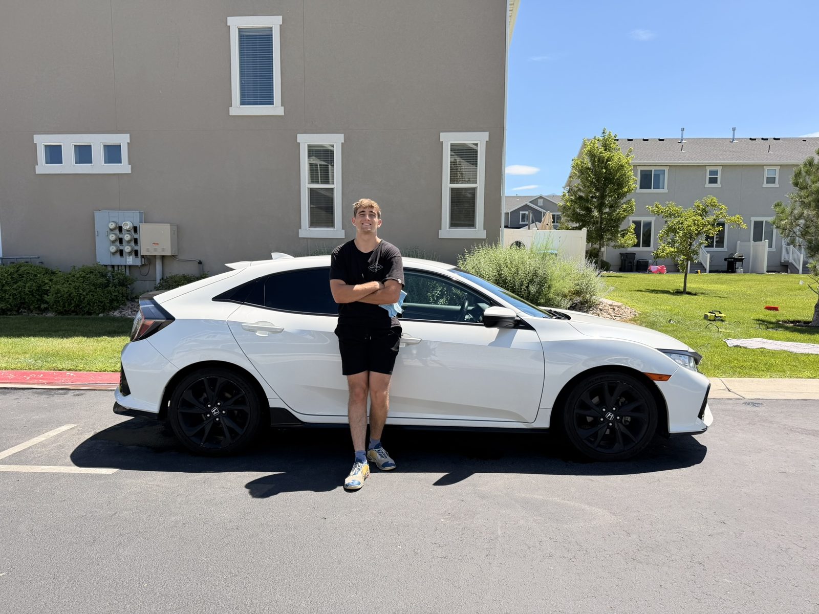 Heber, owner of White Ridge Detailing, with a freshly detailed white Honda Civic in Orem, Utah